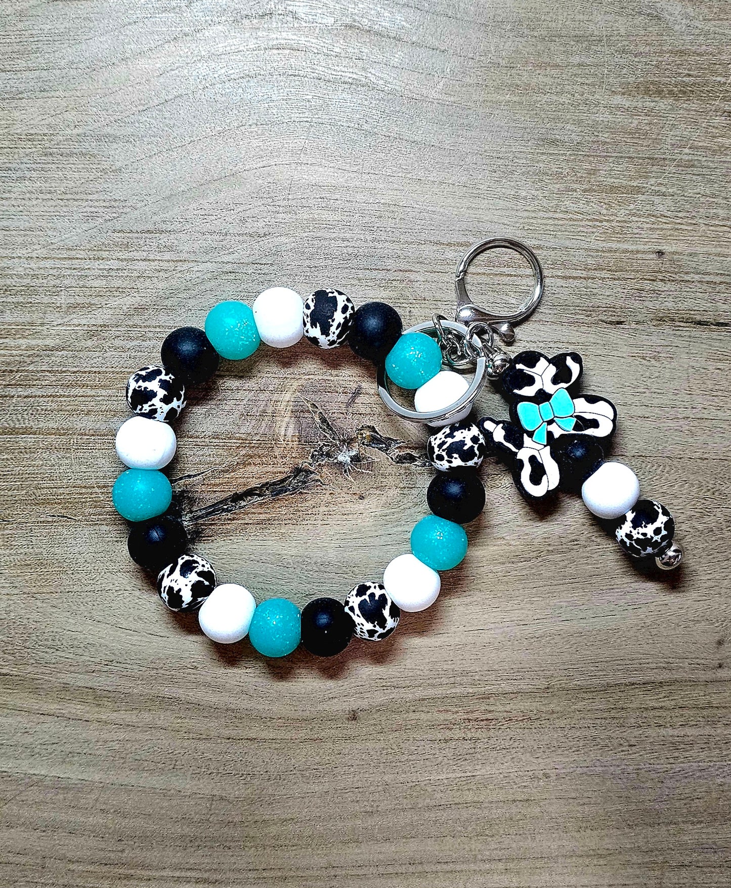 Handmade cow print beadable keychain with black white and turquoise silicone beads and cow print balloon dog charm